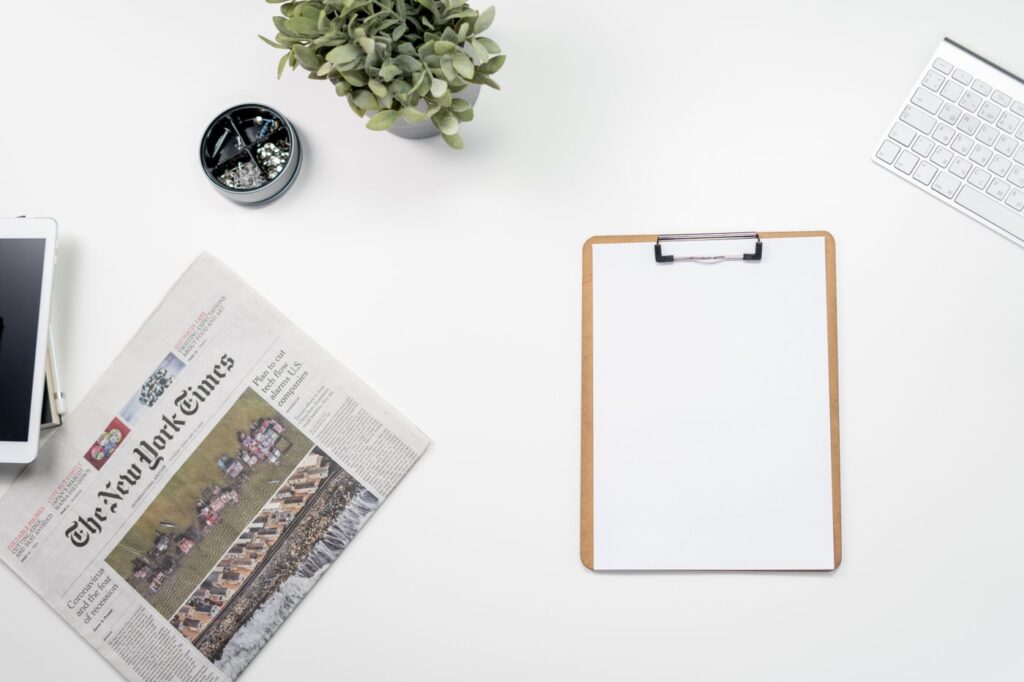 Journal, clavier et bloc-notes sur un bureau clair